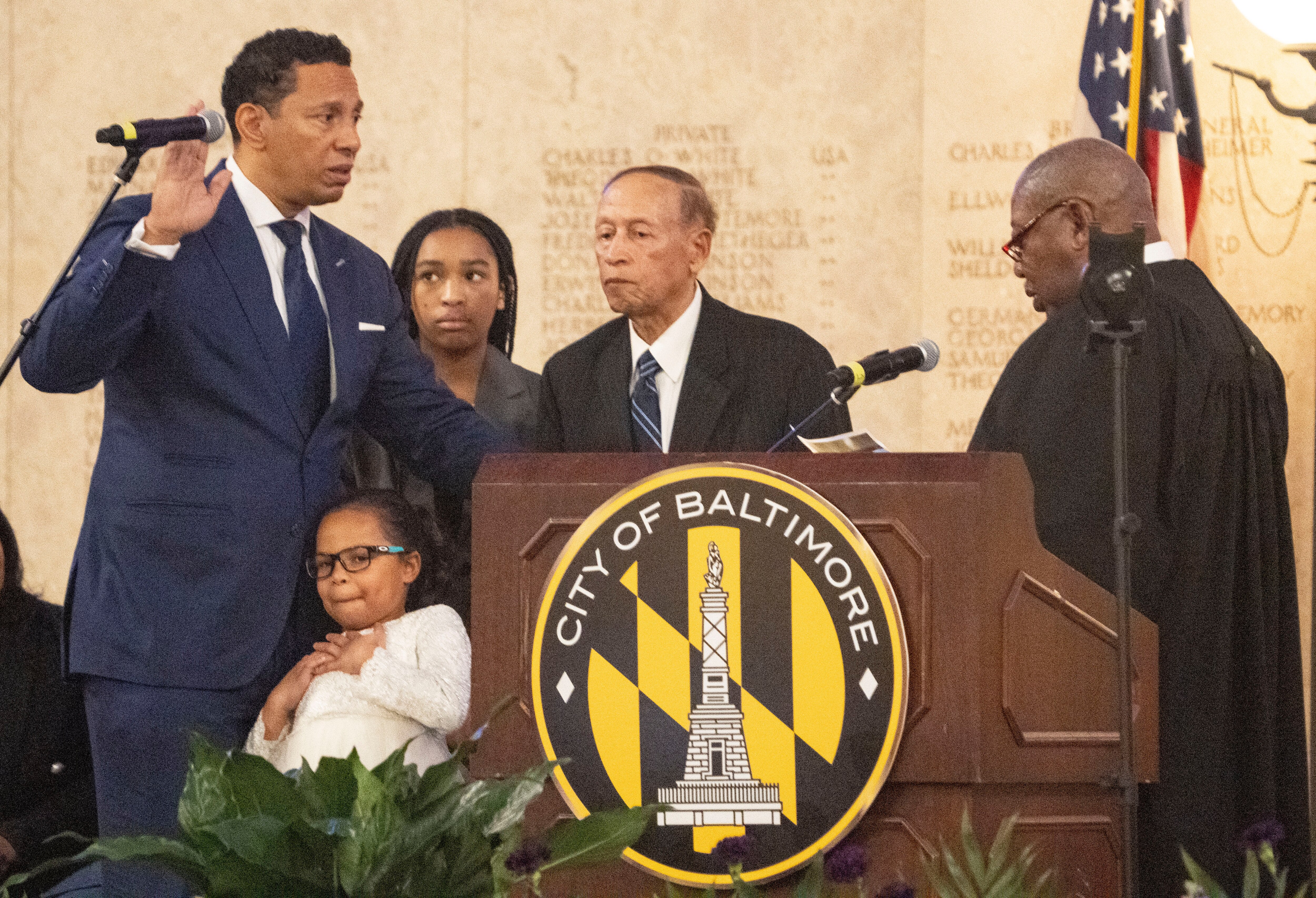 Retired Baltimore Circuit Judge David B. Mitchell, right, administers the oath of office to Ivan Bates, far left, as he is sworn in as the new Baltimore state's attorney, on Tuesday, Jan. 3, 2023, at the Baltimore War Memorial.