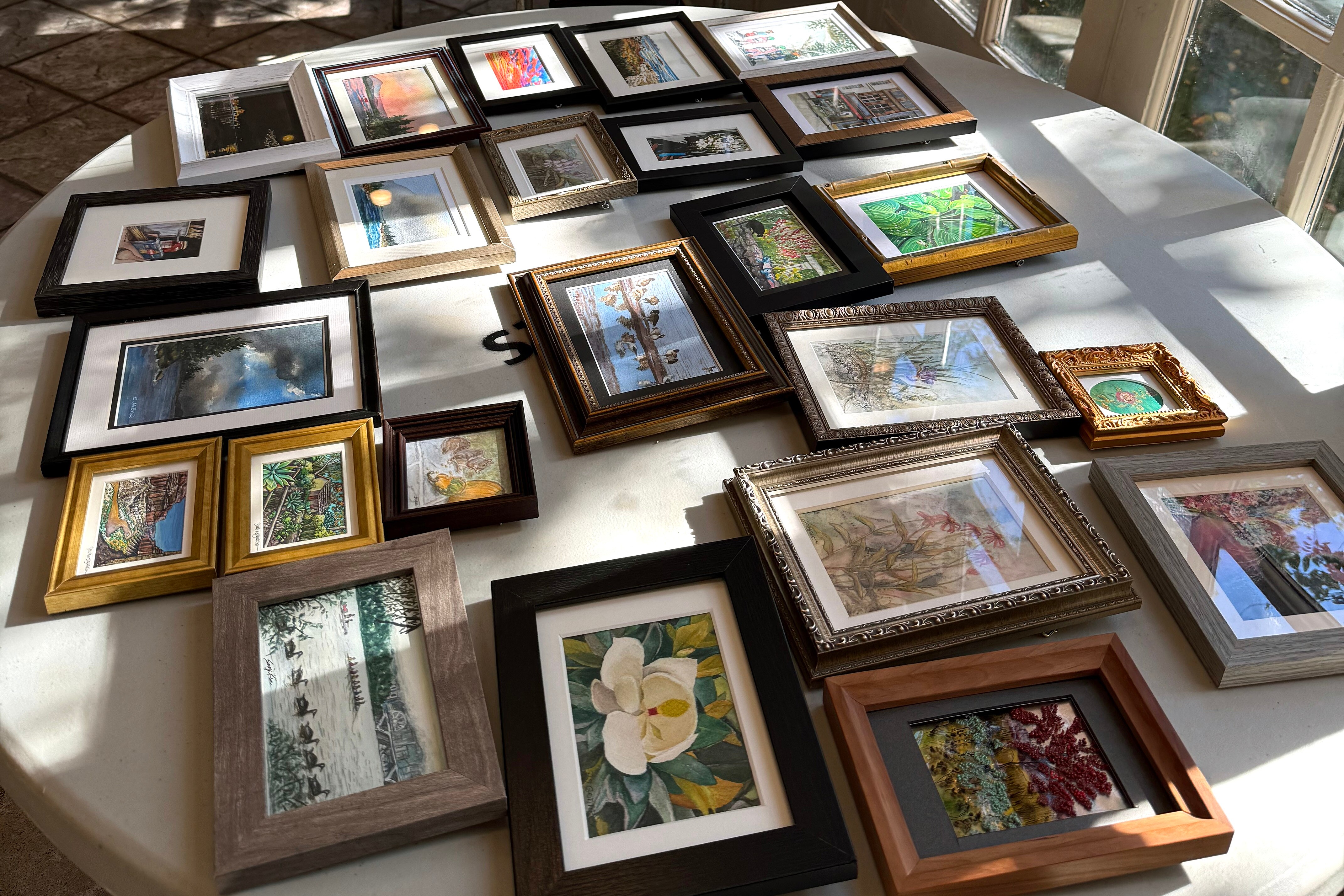 Some of nearly 700 works of miniature art are laid out for processing before going on display at the Mansion at Strathmore starting Nov. 22 at 1 p.m.
