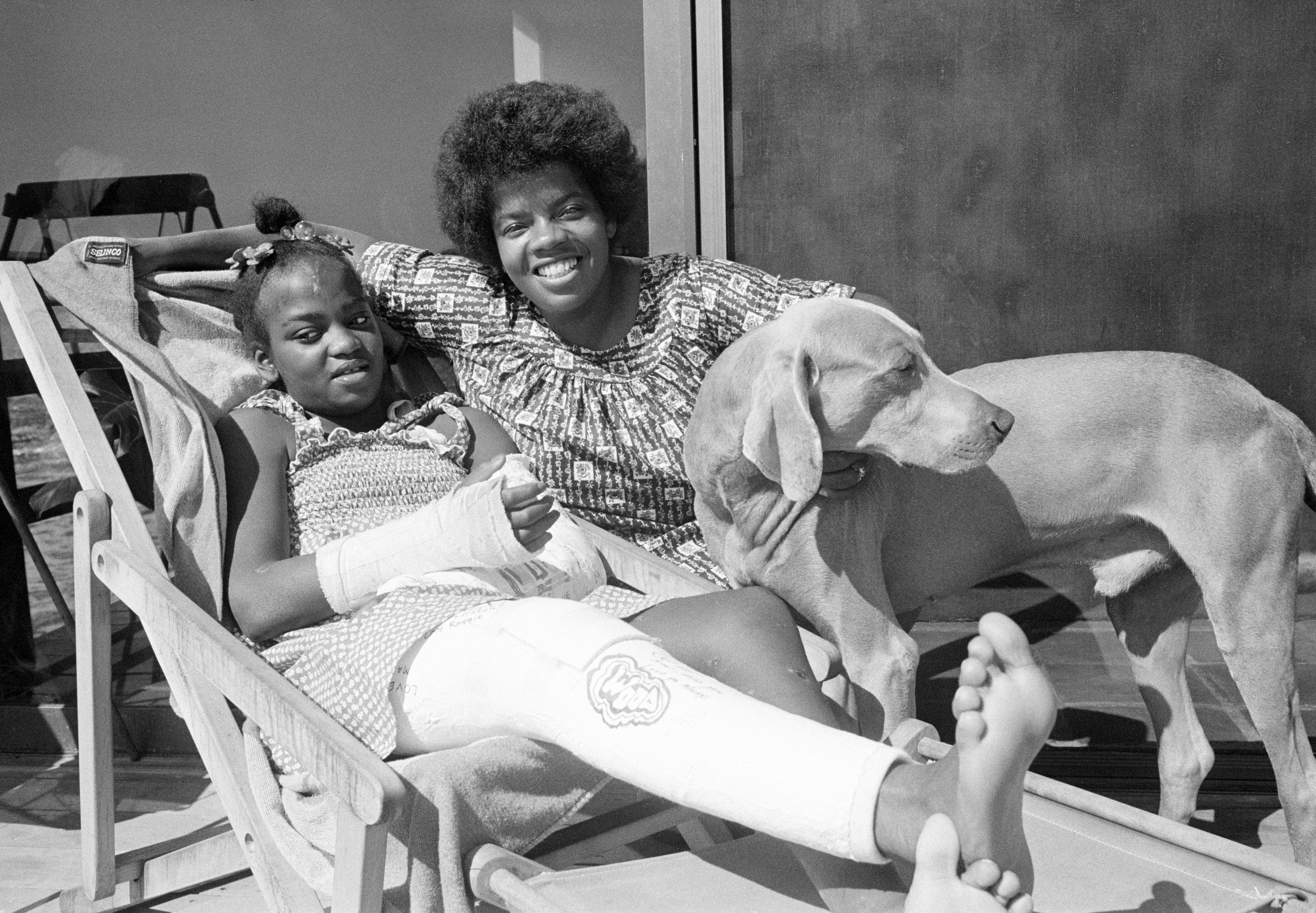 Twelve-year-old television actress Danielle Spencer rests at home in Malibu, C.A. after her release from Santa Monica Hospital on Friday, Sept. 16, 1977. Danielle is recovering from a car accident that killed her father, actor Timothy Pelt. With Danielle is her mother Cheryl Pelt and her pet dog. (AP Photo/Nick Ut)