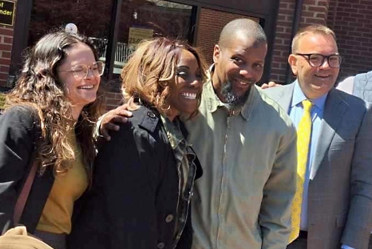 Zenobia McBride and Chris McBride stand in the middle of his attorneys, Rachel Fluriach and James Johnston, on April 7 outside the Frederick County Courthouse after his resentencing.