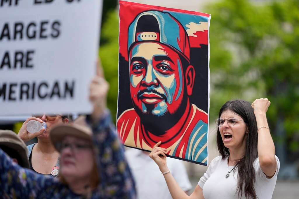 Brianna O'Keefe yells as she holds a portrait of Kilmar Obrego Garcia during a protest outside the federal courthouse Wednesday, June 25, 2025, in Nashville, Tenn.