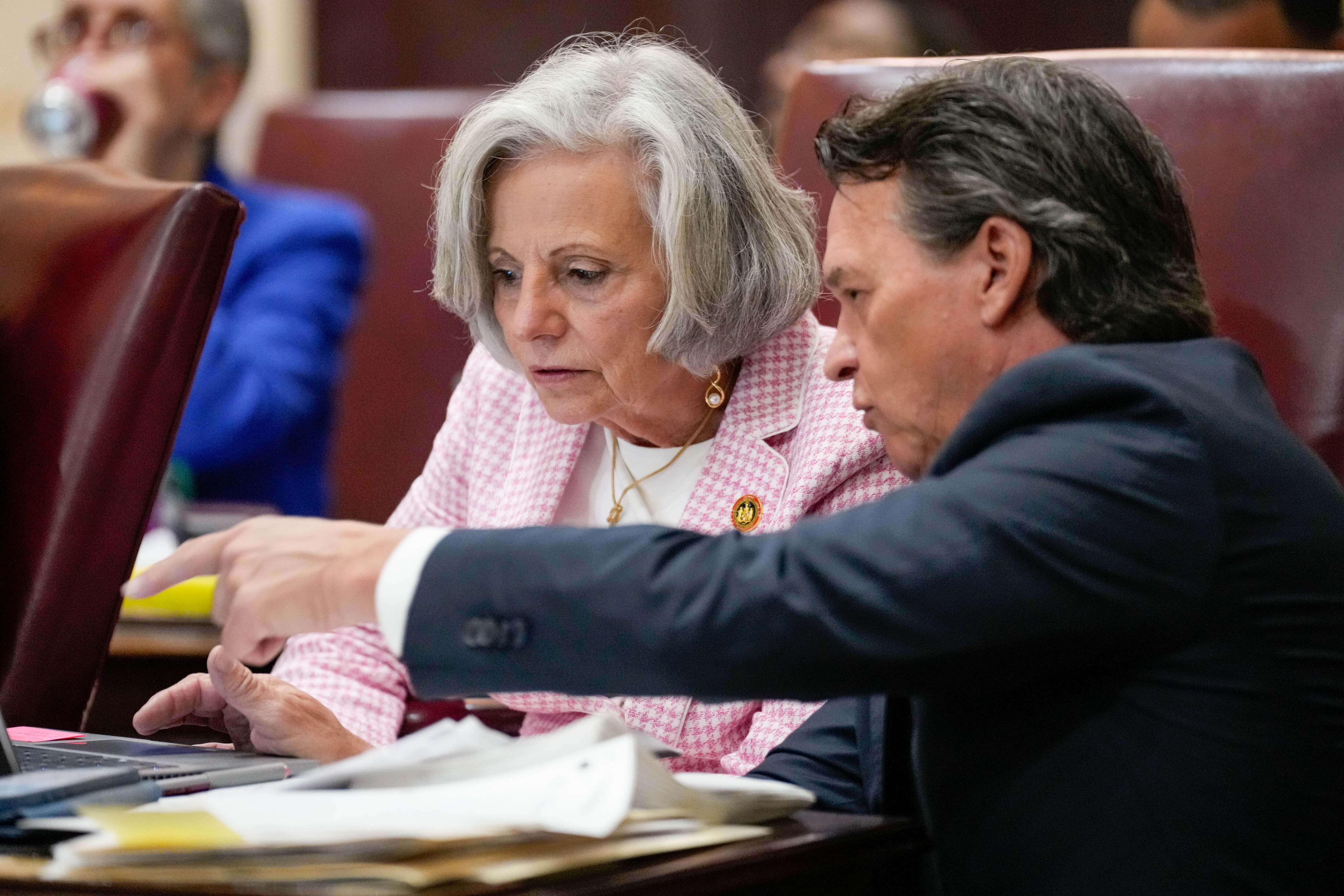 Sen. Pam Beidle, left, and Sen. Stephen Hershey Jr. discuss a bill in the Senate chamber at the Maryland State House in Annapolis last month.