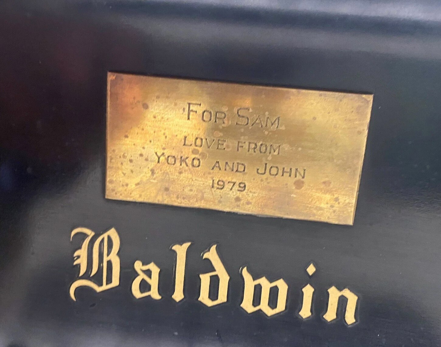 The plaque above the keyboard of the 1929 piano shows it was a gift to Sam Green from John Lennon and Yoko Ono.
