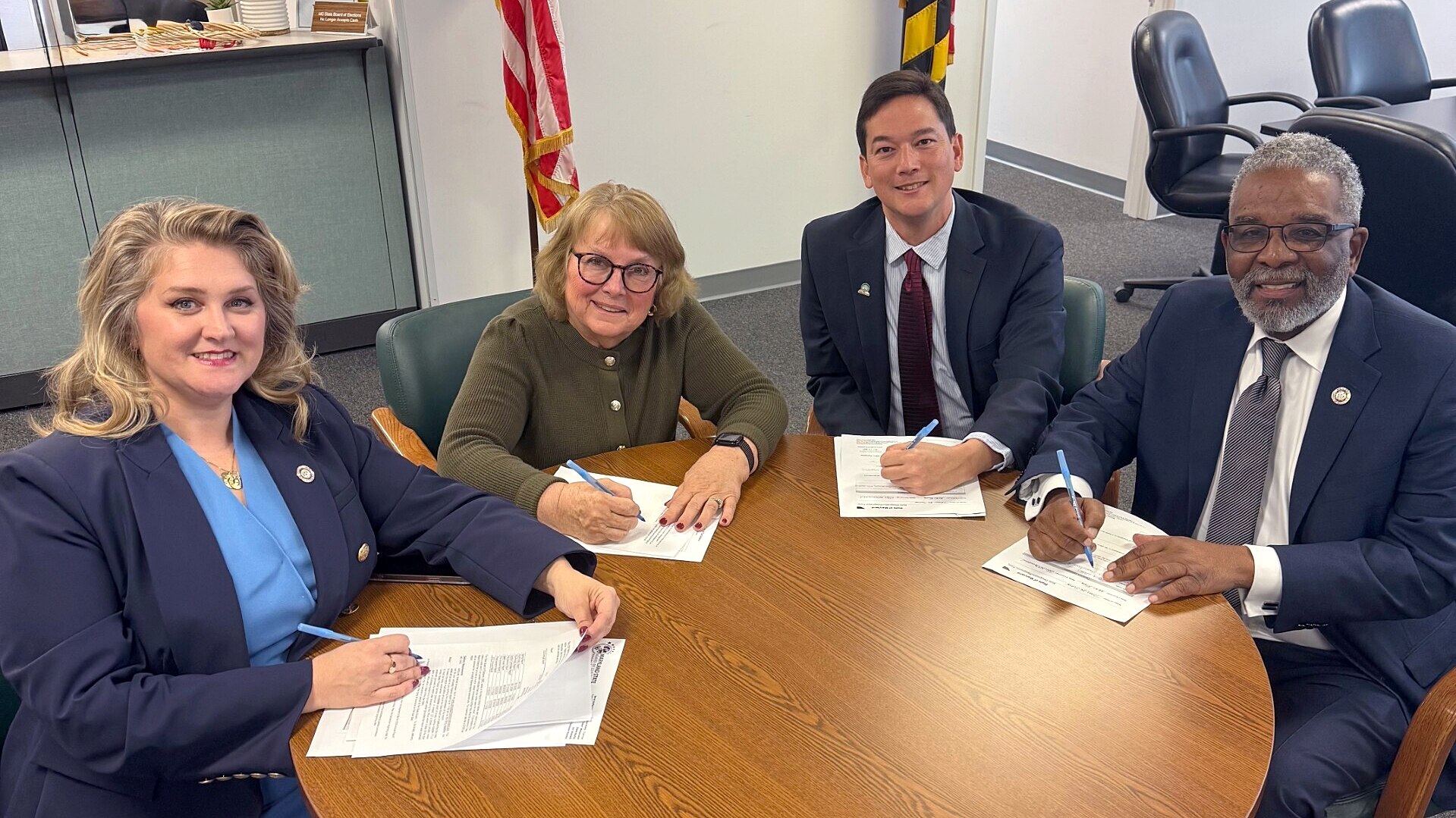 From left, Del. Lesley Lopez, Sen. Nancy King, Gaithersburg City Councilman Robert Wu and Del. Greg Wims sign paperwork at the State Board of Elections on Friday.