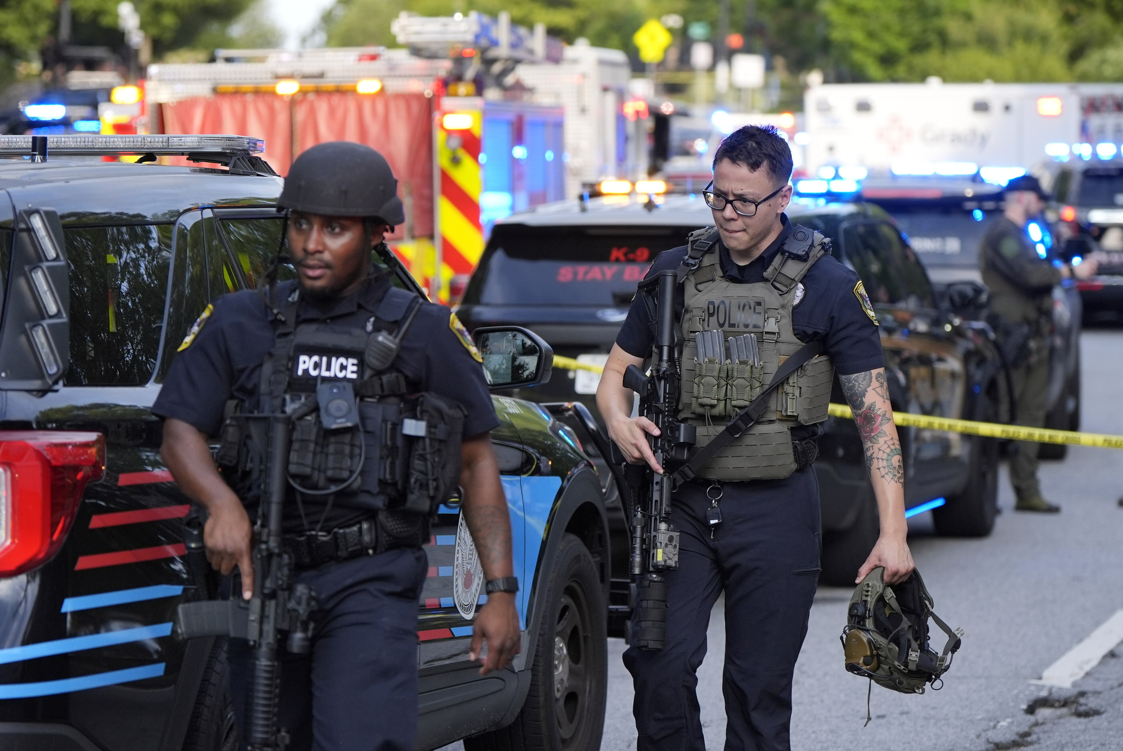 Armed police officers walk near the scene of shooting at the Emory University in Atlanta on Friday, Aug. 8, 2025. (AP Photo/Mike Stewart)