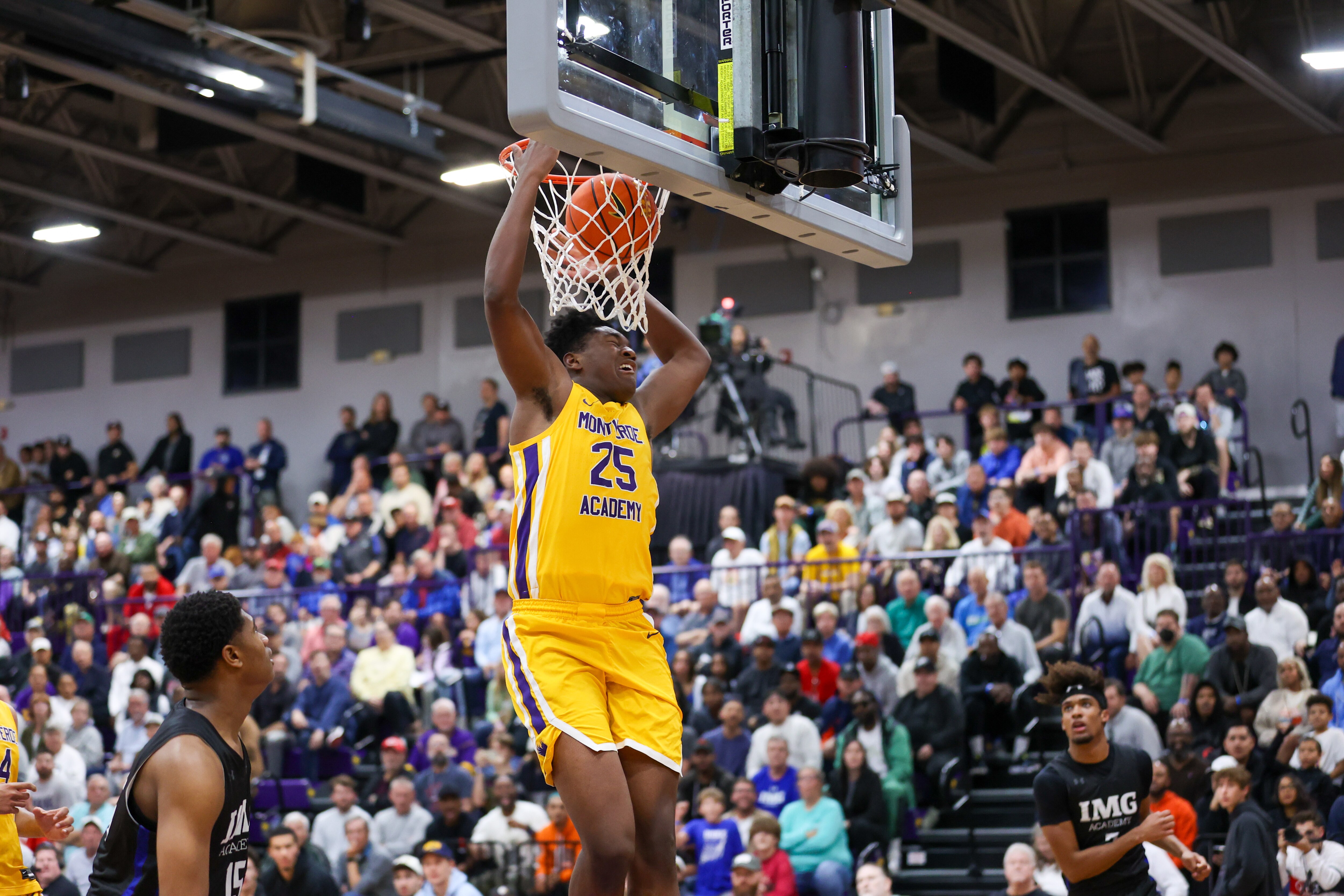 Baltimore native Derik Queen, a star big man for the Montverde Academy boys basketball team, goes up for a dunk against IMG Academy in a December 2023 game.