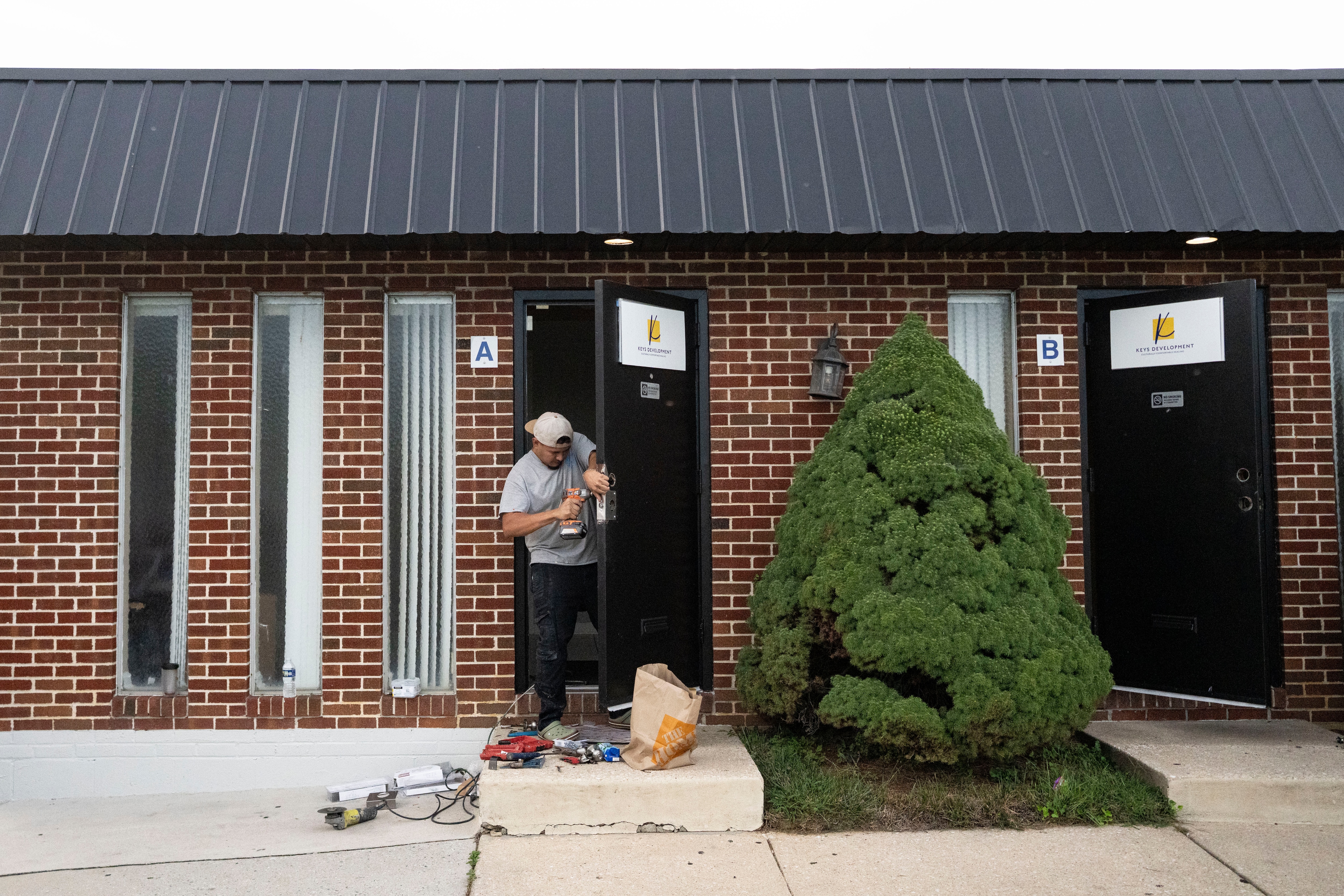 A man repairs a door at the KEYS Development building in Baltimore on Wednesday. 
