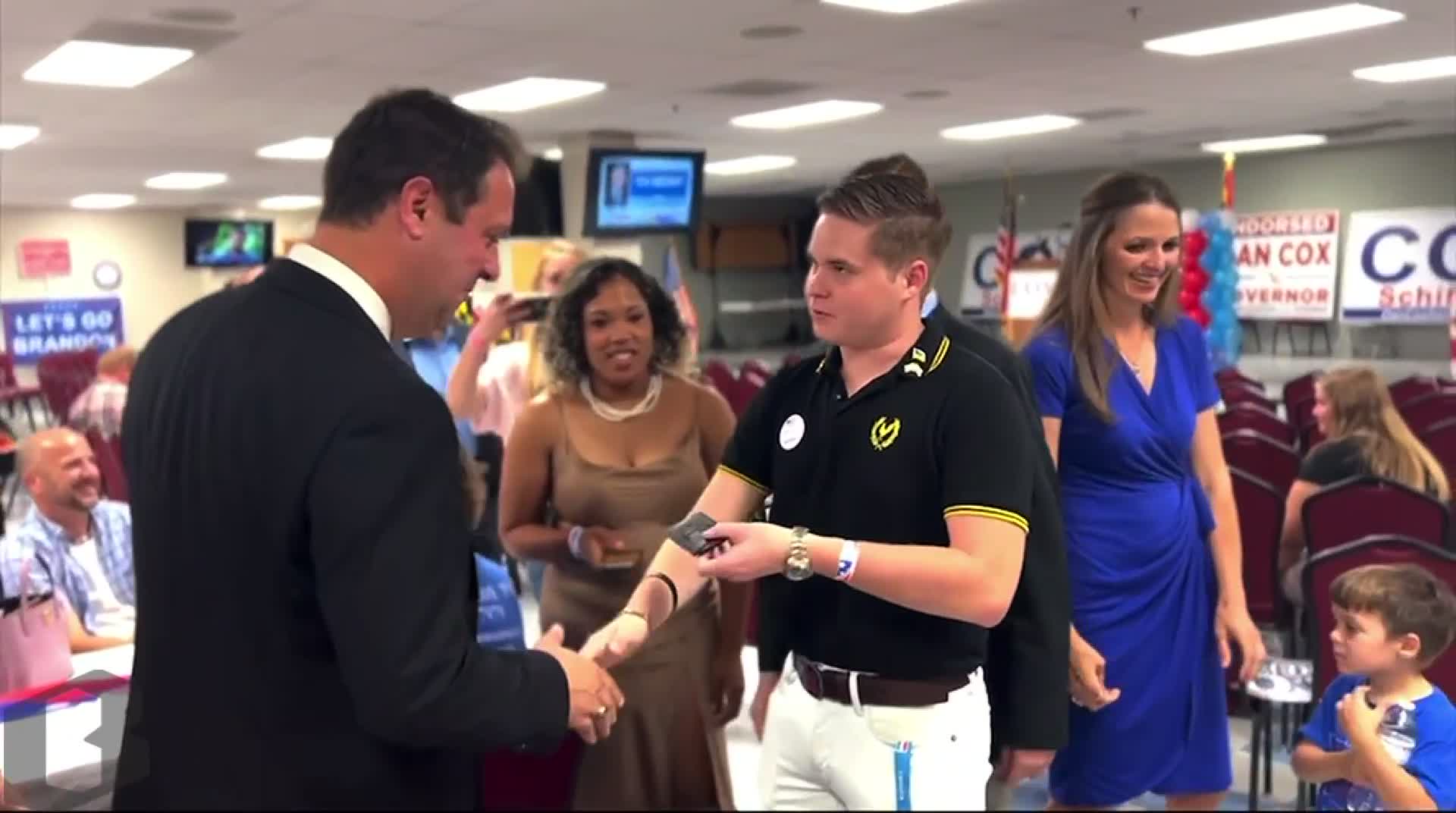 Republican governor candidate Dan Cox accepts a gifts from a man who identifies himself as a Proud Boy after securing the nomination in July.